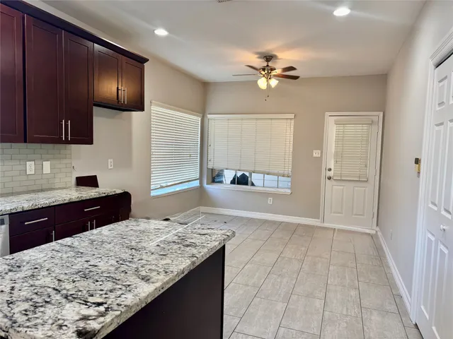 a kitchen with kitchen island granite countertop a refrigerator and a sink