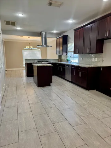 a large kitchen with granite countertop a stove a sink and a microwave