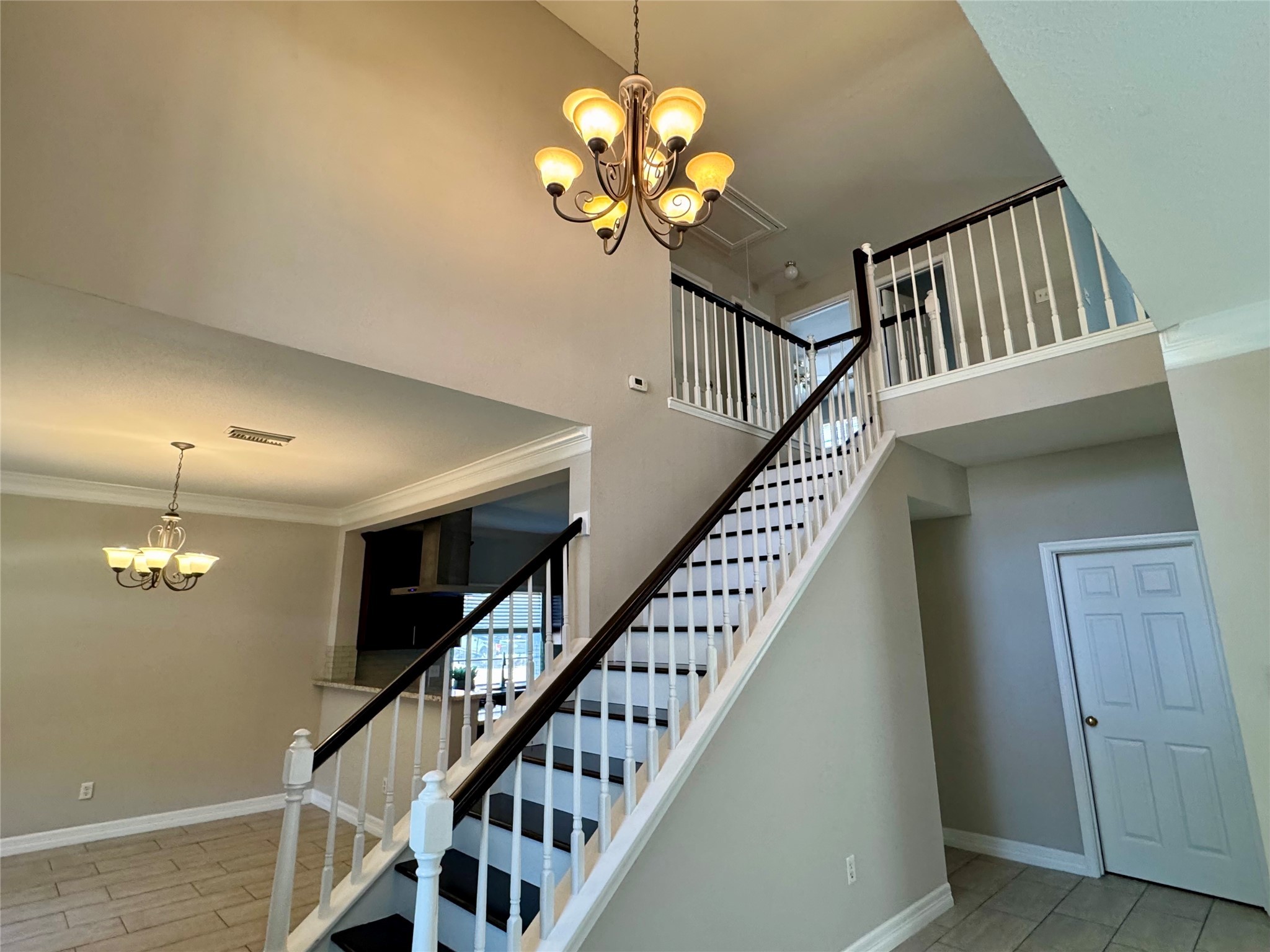 5722 Fort Sumter Lane Houston, TX 77084 - Photo 10 of 22 a view of staircase with wooden floor and chandelier