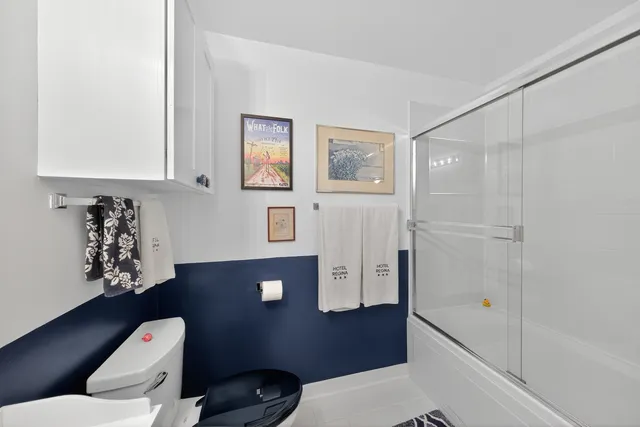 a bedroom with a bed and a lamp on dresser