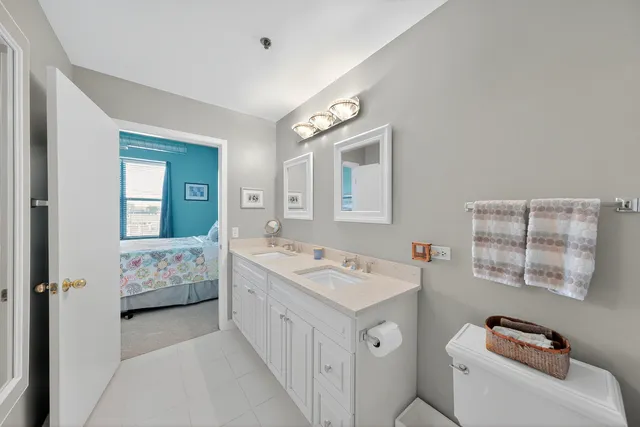 a spacious bathroom with a double vanity sink toilet and shower