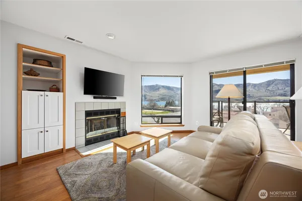 a living room with furniture a fireplace and a flat screen tv