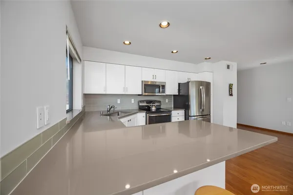 a kitchen with stainless steel appliances a refrigerator sink and stove