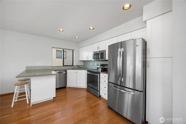 a kitchen with a refrigerator cabinets and wooden floor