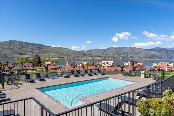 an aerial view of house with yard swimming pool and mountain view in back