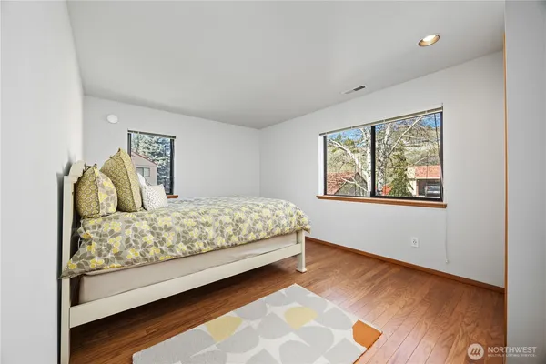 a bedroom with a bed and wooden floor