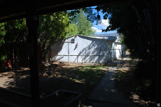 116 North 3rd Street Tooele, UT 84074 - Photo 34 of 45 Expansive rear yard with a storage shed, established trees, and a paved pathway