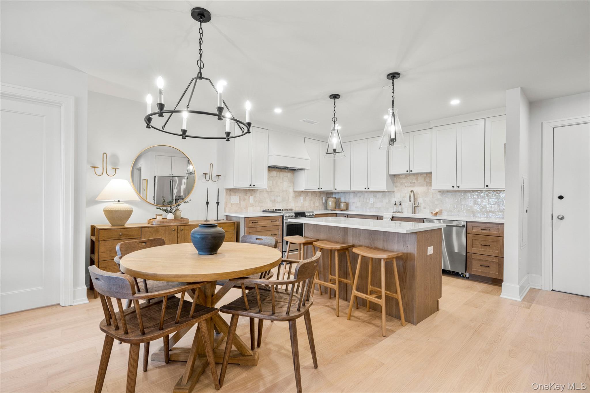 25 South Riverside Avenue, Unit 309 Croton-on-Hudson, NY 10520 - Photo 8 of 26 a kitchen with stainless steel appliances kitchen island granite countertop a table chairs and a refrigerator