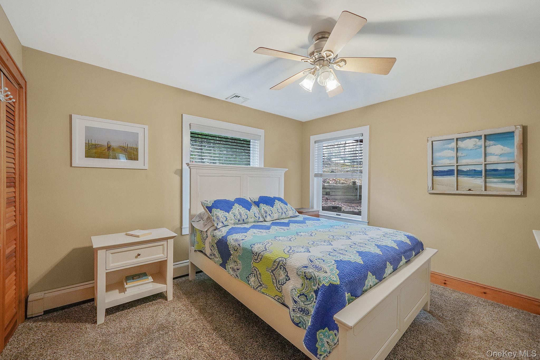 1745 Bay View Avenue Mattituck, NY 11952 - Photo 14 of 37 a bedroom with a bed and a chandelier