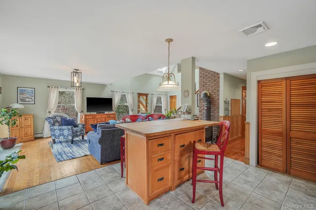 a living room with furniture a flat screen tv and a refrigerator