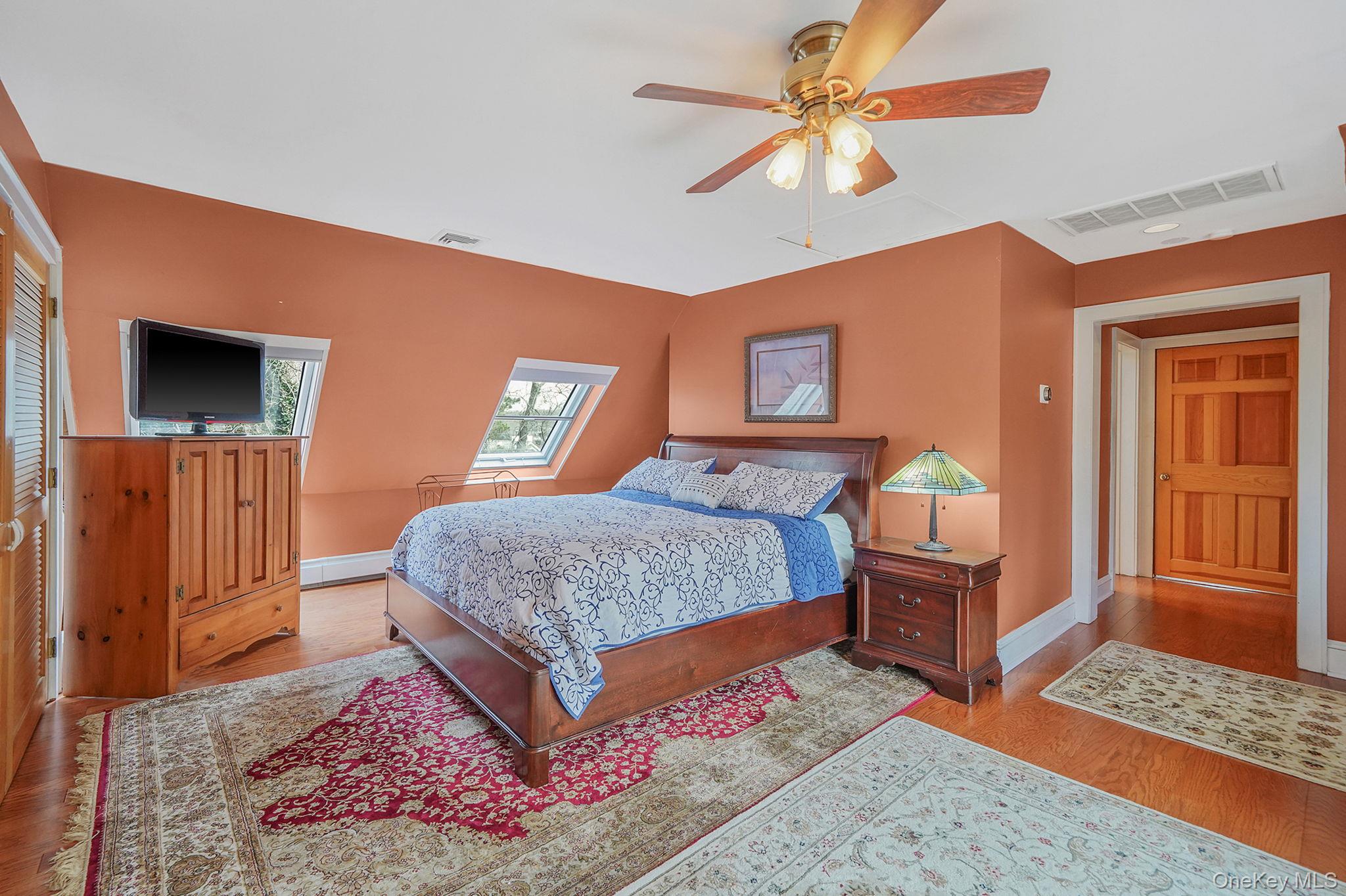 1745 Bay View Avenue Mattituck, NY 11952 - Photo 21 of 37 a bedroom with a bed a dresser and wooden floor
