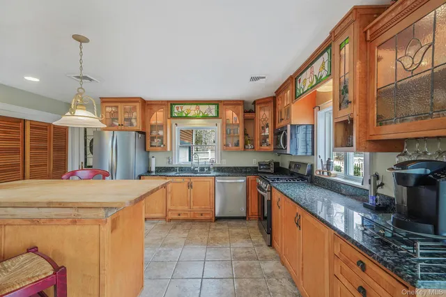 a large kitchen with stainless steel appliances granite countertop a sink and a stove