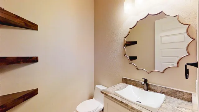 a bathroom with a sink a toilet and mirror