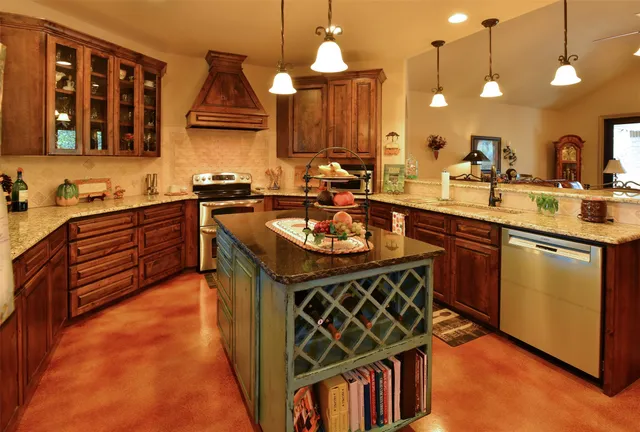 a kitchen with stainless steel appliances granite countertop a sink a stove and a wooden floors