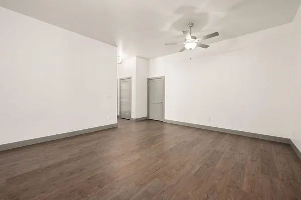 a view of an empty room with wooden floor