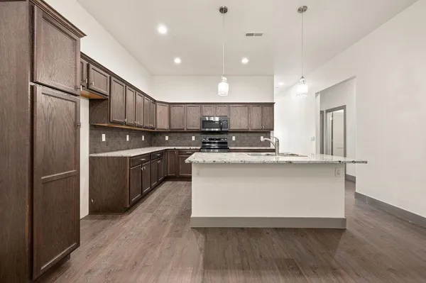 a kitchen with kitchen island stainless steel appliances a sink and refrigerator