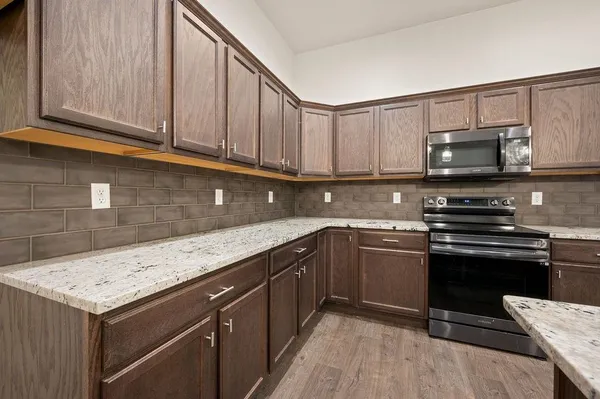 a kitchen with stainless steel appliances granite countertop a stove a sink and a microwave