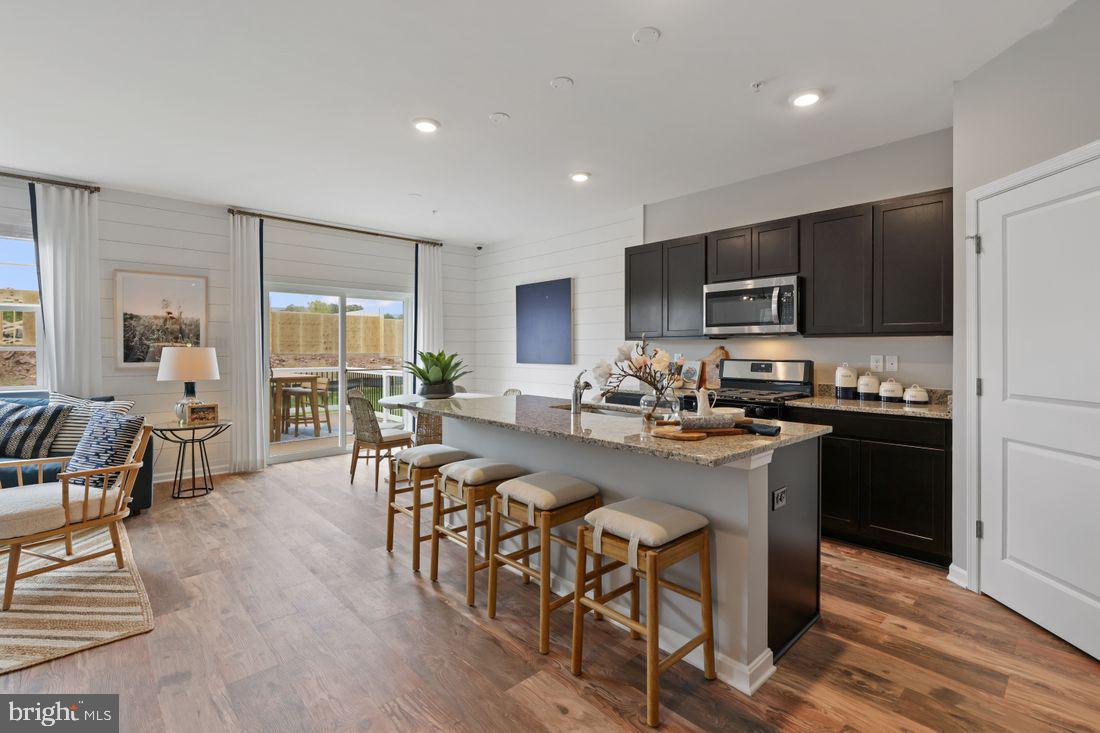 92 Open Gate Lane Shepherdstown, WV 25443 - Photo 11 of 40 a kitchen with stainless steel appliances granite countertop a stove a refrigerator a kitchen island a dining table and chairs