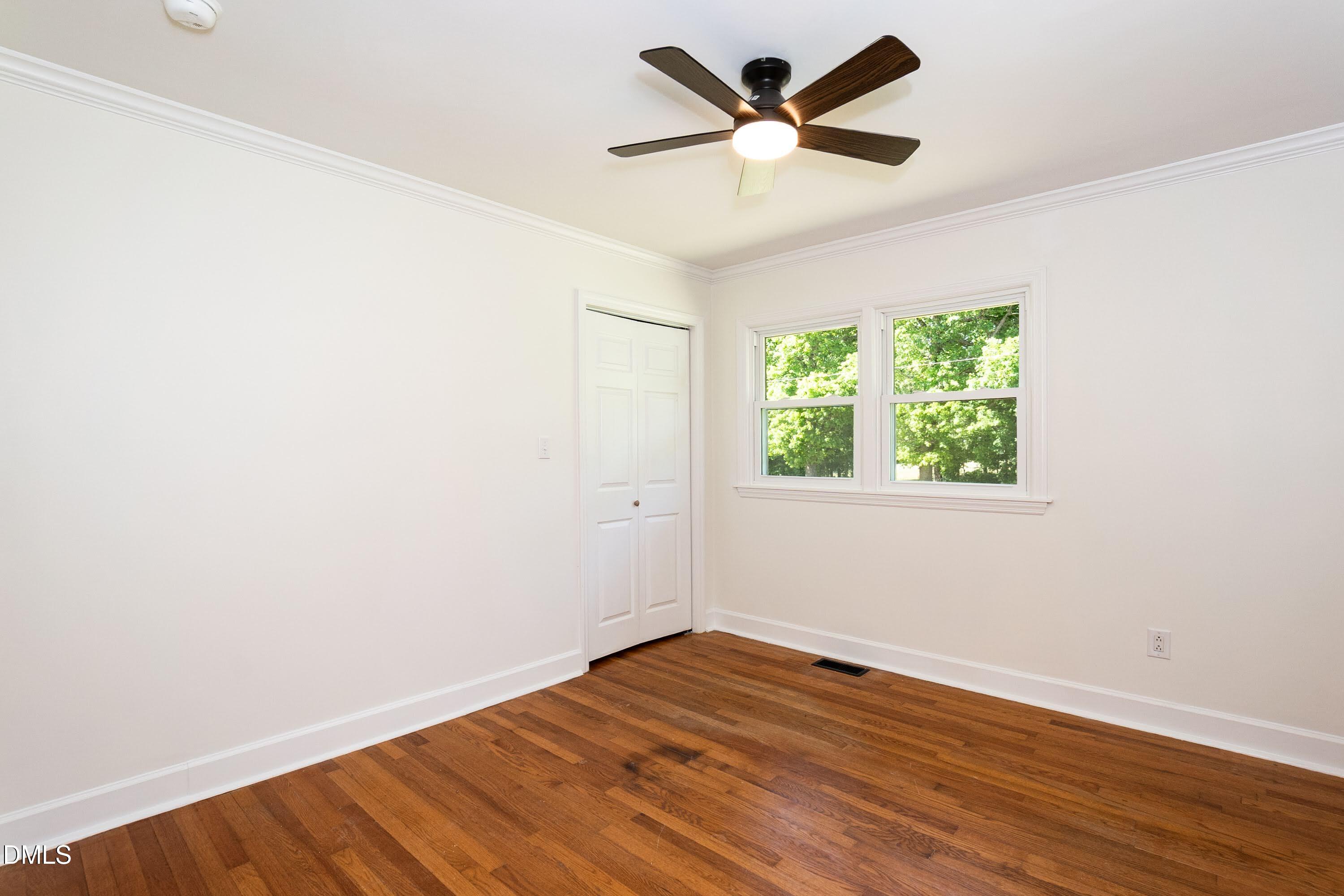 641 Rocky Ford Road Louisburg, NC 27549 - Photo 15 of 38 an empty room with wooden floor and windows