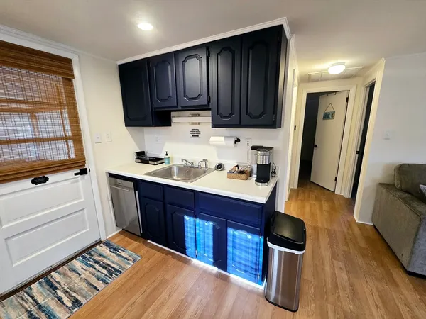 a kitchen with wooden floors and wooden cabinets