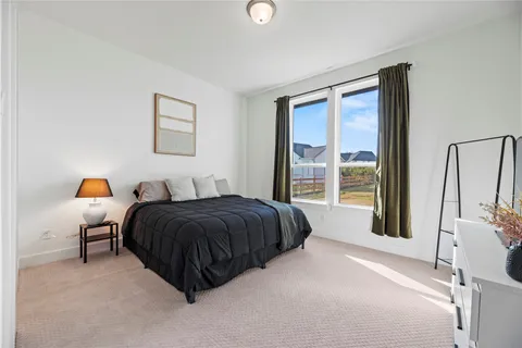 a spacious bedroom with a bed and a large window