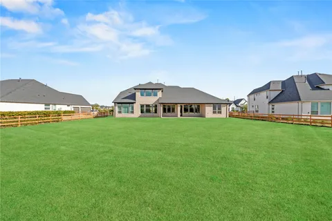 a view of a house with a big yard and large trees