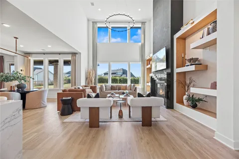 a living room with fireplace furniture and a large window