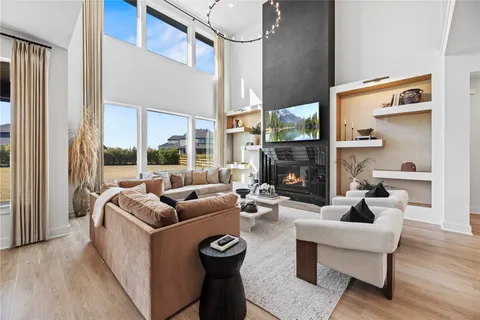 a living room with furniture a large window and a fireplace