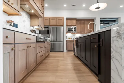 a kitchen with stainless steel appliances granite countertop a refrigerator and a sink