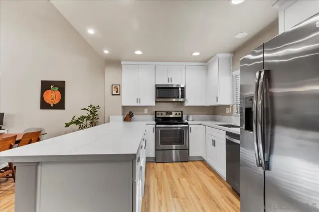 a large kitchen with cabinets stainless steel appliances and a counter top space