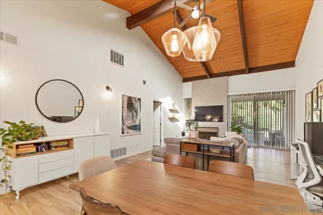 a living room with furniture a flat screen tv and kitchen view