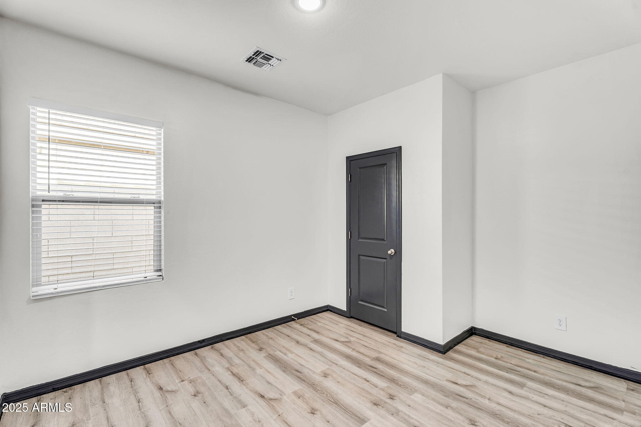 6113 East Athena Road Florence, AZ 85132 - Photo 11 of 19 a view of an empty room with wooden floor and a window
