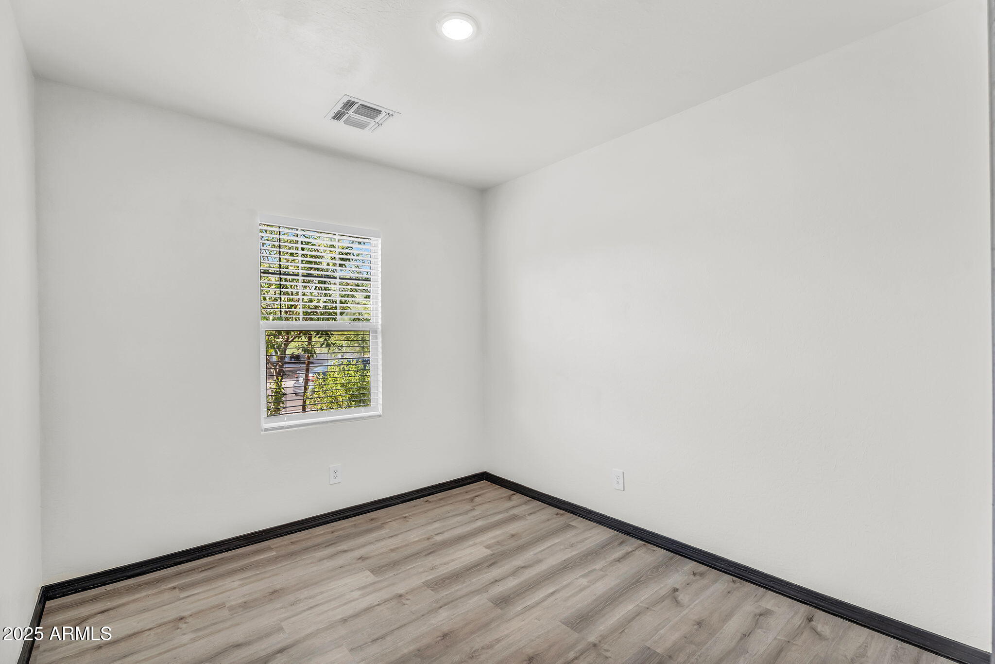 6113 East Athena Road Florence, AZ 85132 - Photo 12 of 19 an empty room with wooden floor and windows