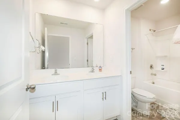 a bathroom with a sink toilet vanity and shower