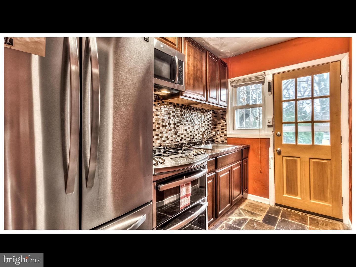 a open kitchen with stainless steel appliances granite countertop a refrigerator and a stove