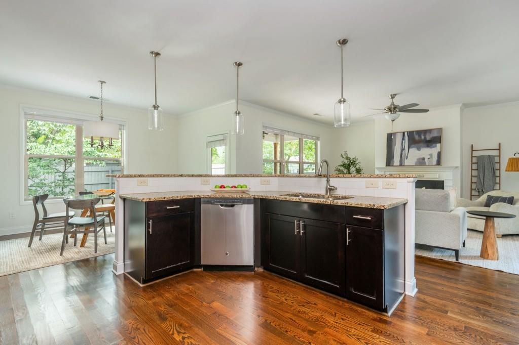 371 Hooper Street Southeast Atlanta, GA 30317 - Photo 14 of 29 a kitchen with kitchen island granite countertop a stove a sink a center island and wooden floor