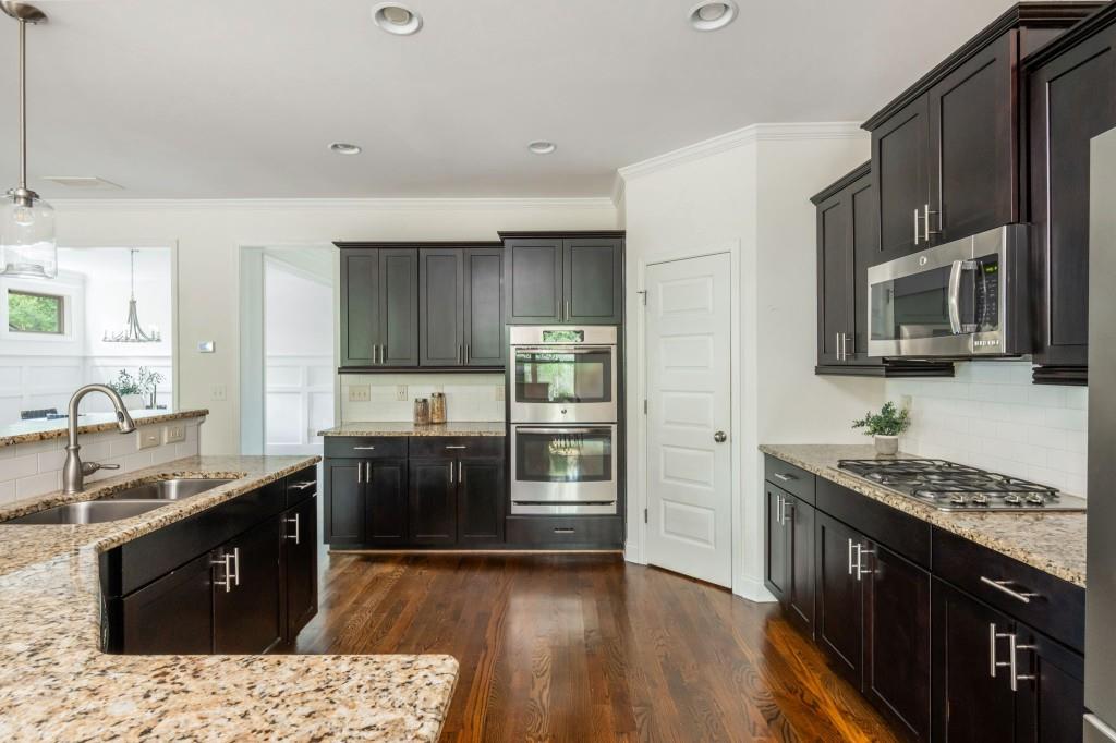 371 Hooper Street Southeast Atlanta, GA 30317 - Photo 15 of 29 a kitchen with stainless steel appliances granite countertop a stove a sink dishwasher a refrigerator and a microwave oven with wooden cabinets