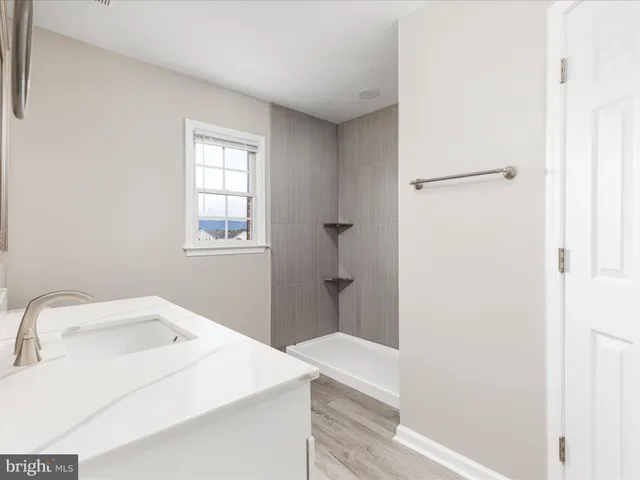 a bathroom with a toilet a sink a mirror and a window