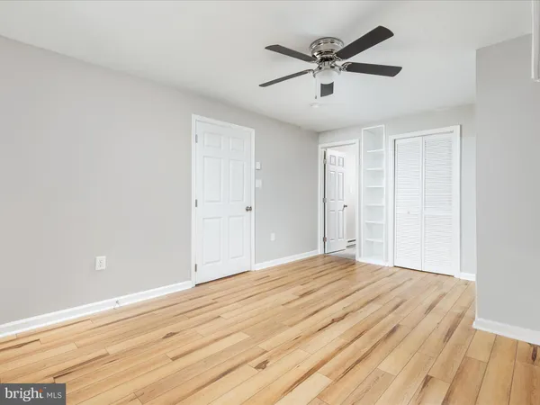a view of a room with wooden floor and ceiling fan
