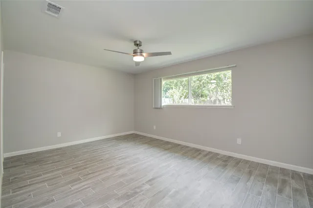 wooden floor in an empty room with a window