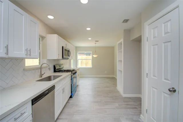 a kitchen with stainless steel appliances granite countertop a sink and cabinets