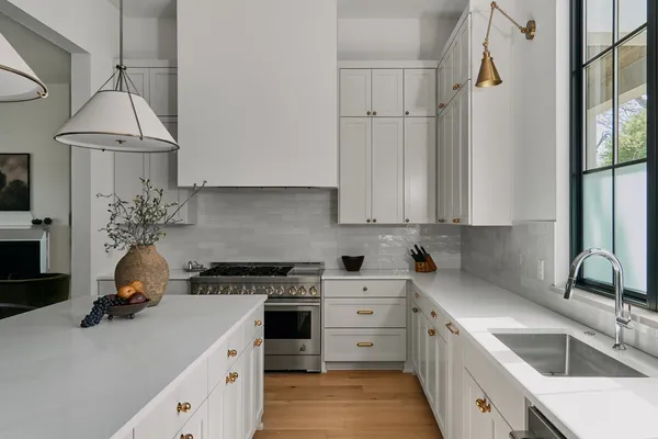 a kitchen with granite countertop a sink stainless steel appliances and cabinets
