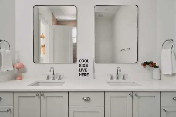 a bathroom with double sink and a mirror