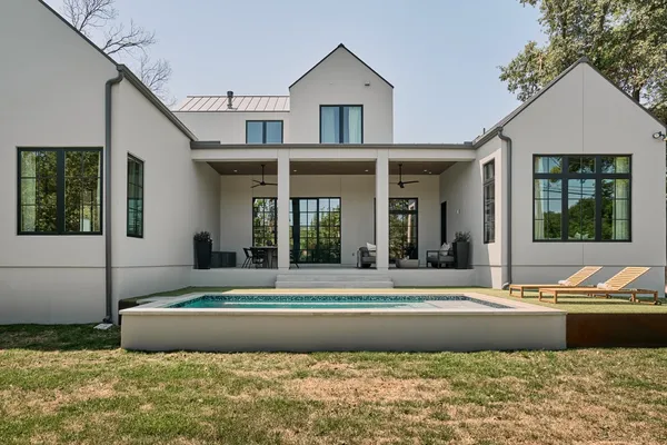 a view of a house with a swimming pool and a dining table and chairs