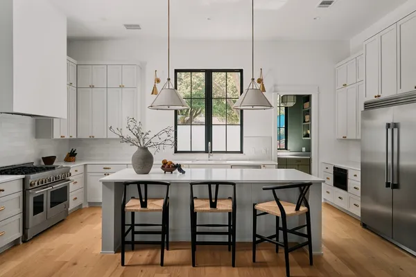 a kitchen with stainless steel appliances a dining table chairs and granite counter tops