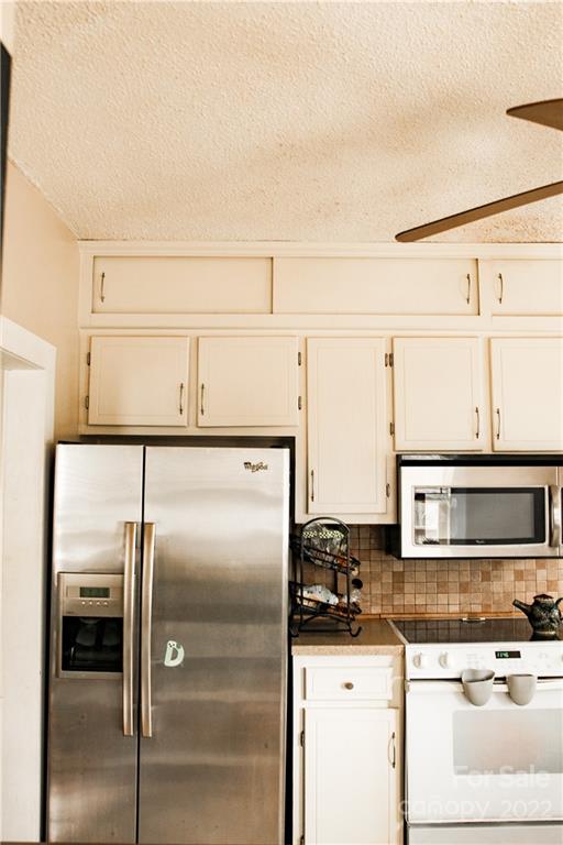 1052 Greenwood Road Spruce Pine, NC 28777 - Photo 13 of 43 a kitchen with granite countertop a refrigerator and a stove top oven