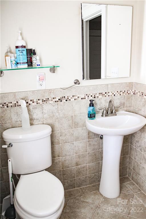 1052 Greenwood Road Spruce Pine, NC 28777 - Photo 37 of 43 a bathroom view with toilet sink and mirror