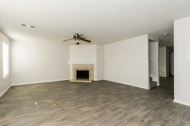 a view of empty room with wooden floor