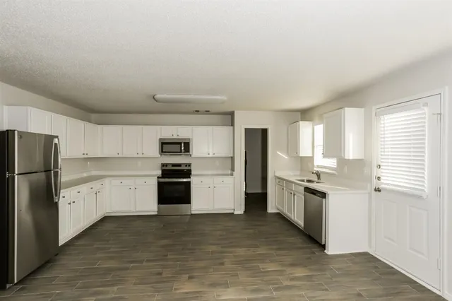 a kitchen with white cabinets and stainless steel appliances