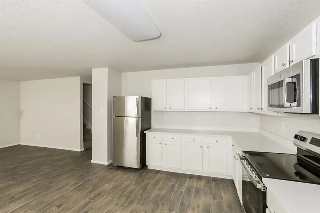 a kitchen with a refrigerator and a stove top oven